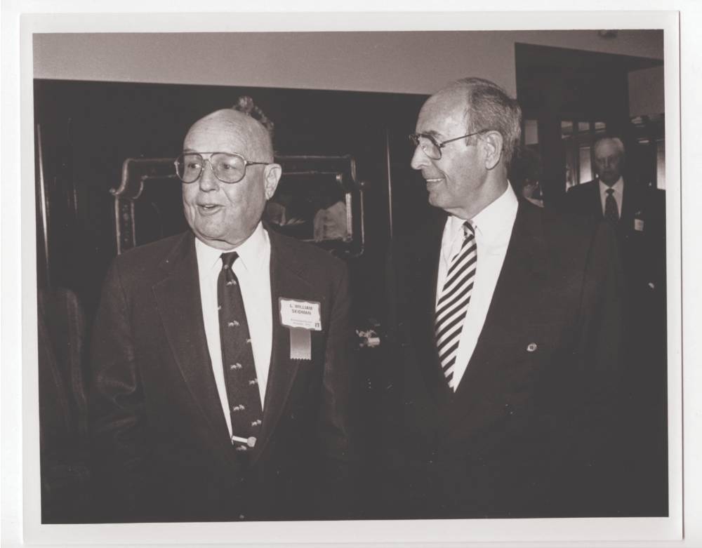 Bill Seidman standing with Richard DeVos.